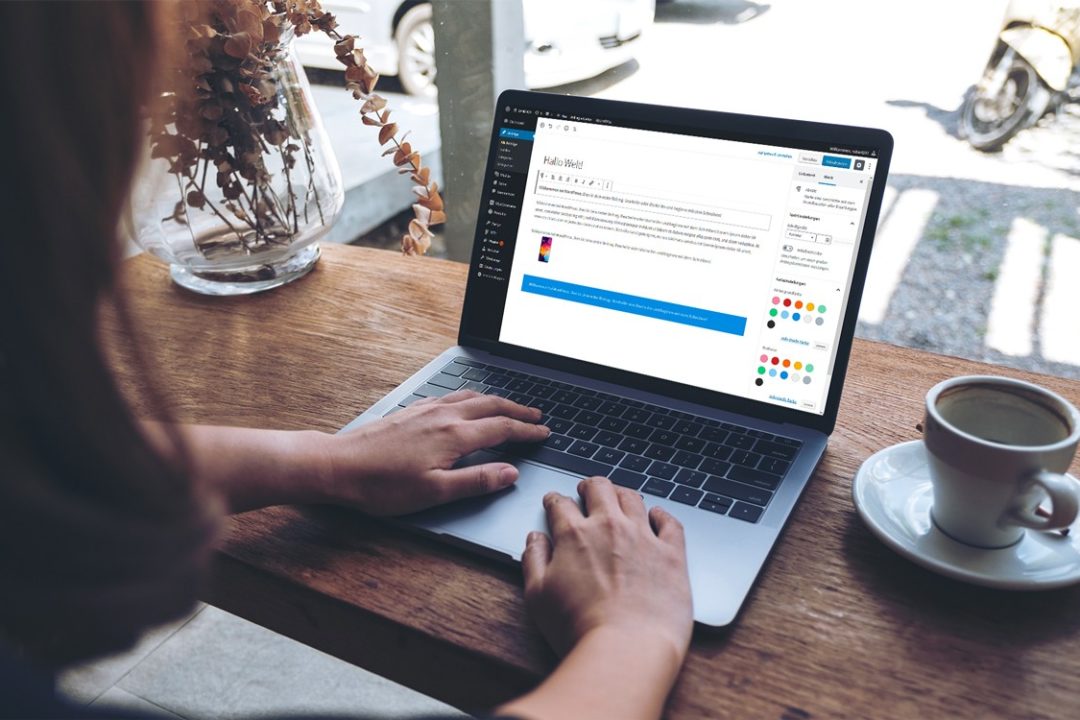 Frau in Cafe arbeitet mit Gutenberg Editor