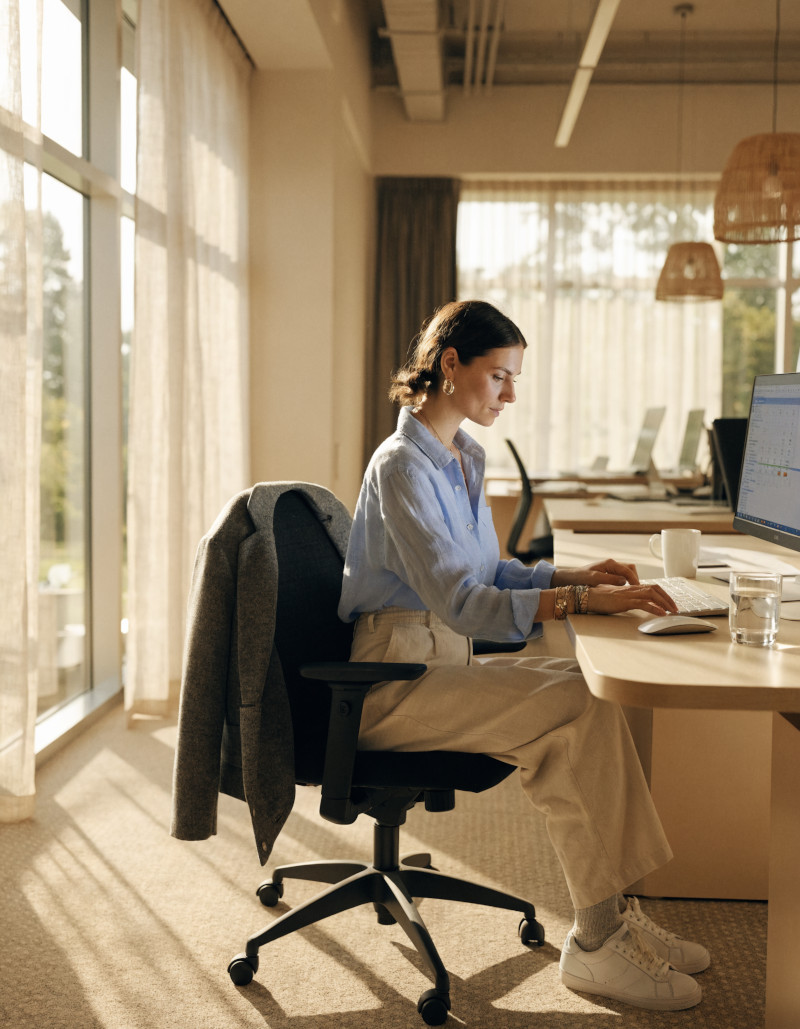 Frau arbeitet am Schreibtisch im Büro.